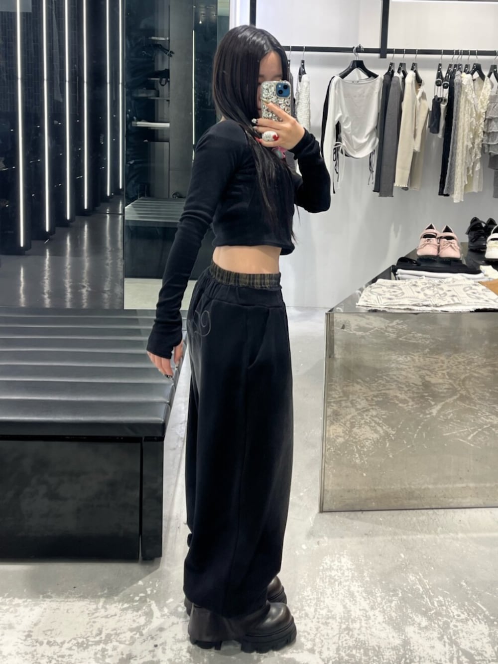 ブラック系のスウェットパンツ、ブラック系のブーツ、ブラック系のTシャツ/カットソーを着用したレディースの春コーディネートの2枚目の写真