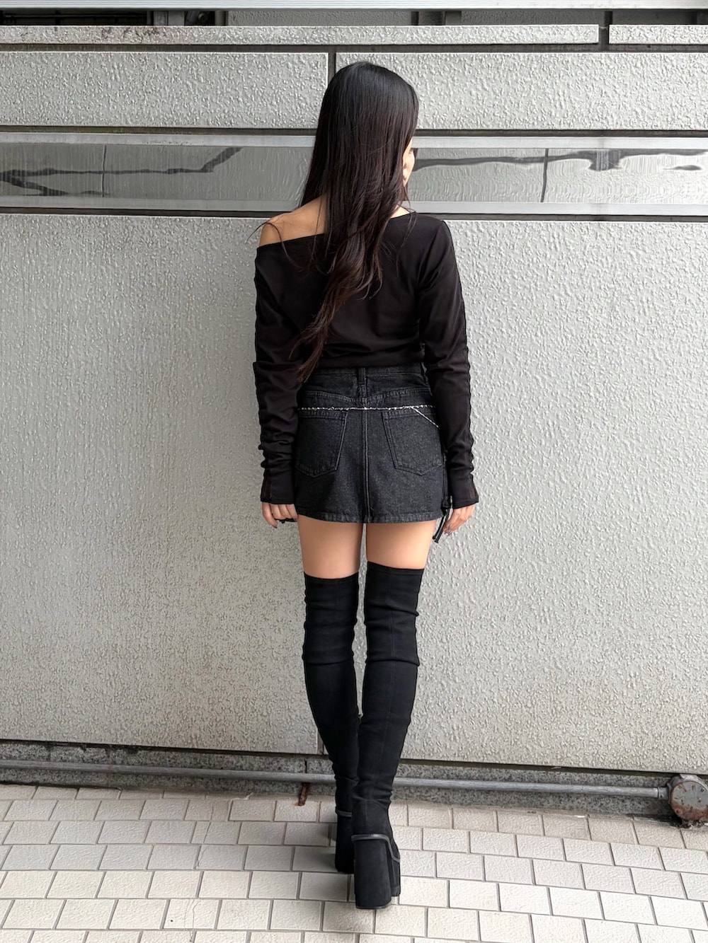 ブラック系のTシャツ/カットソー、ブラック系のスカート、ブラック系のブーツを着用したレディースの秋コーディネートの4枚目の写真