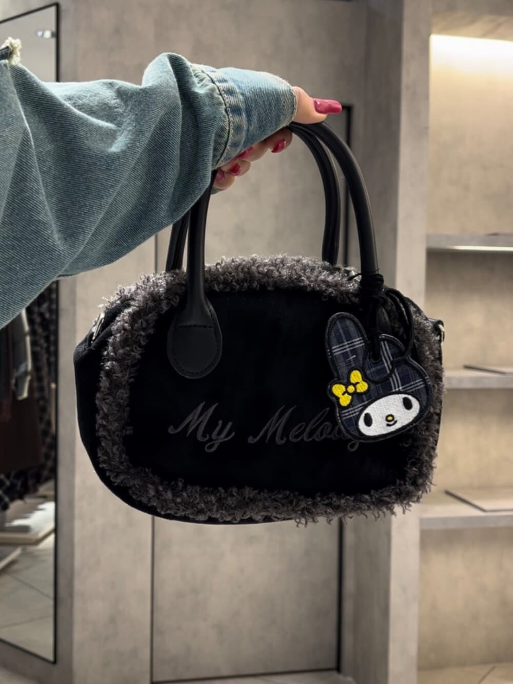 ブラック系のボストンバッグ、ブラック系のブーツ、ブルー系のデニムジャケットを着用したレディースの冬コーディネートの10枚目の写真