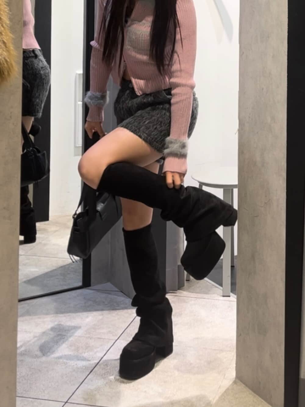 ブラック系のハンドバッグ、ブラック系のブーツ、グレー系のその他パンツを着用したレディースの冬コーディネートの6枚目の写真