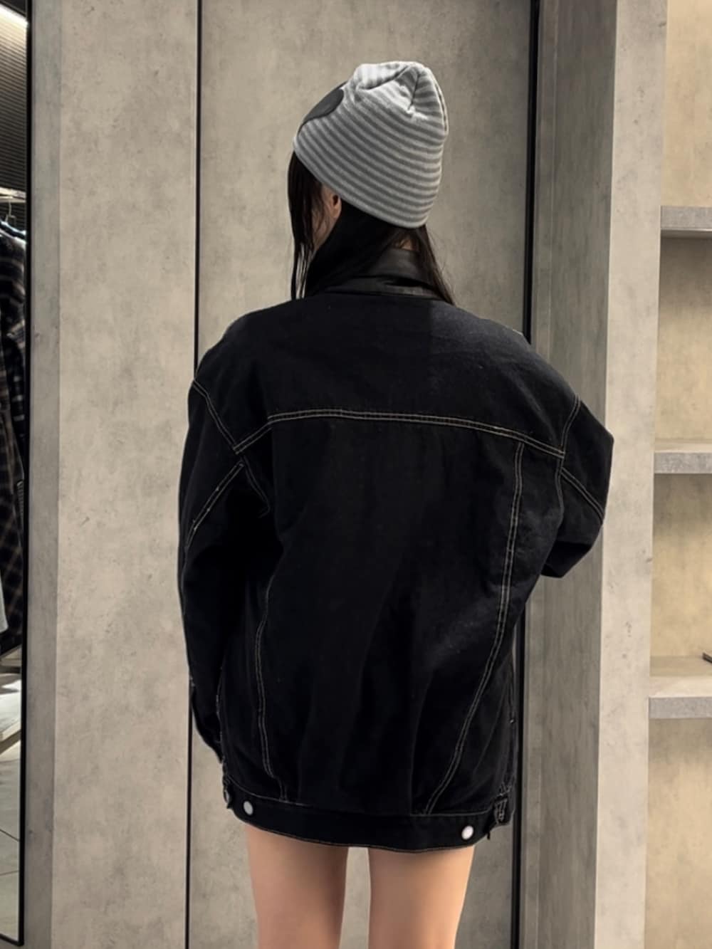 ブルー系のブルゾン、ブラック系のニット/セーター、ブルー系のスカートを着用したレディースの冬コーディネートの8枚目の写真