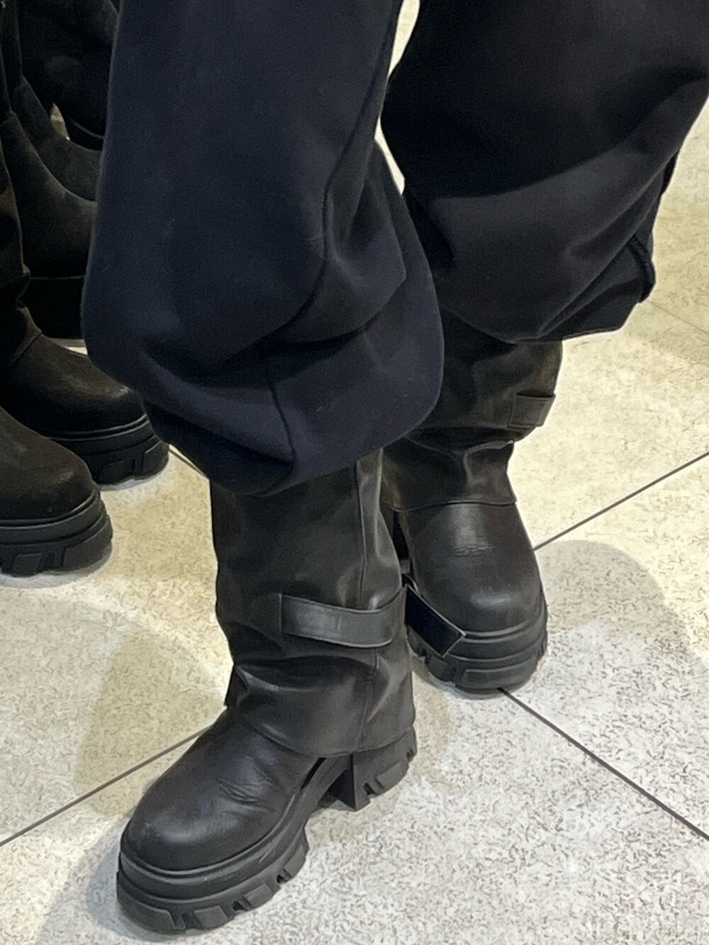 グレー系のニット/セーター、ブラック系のスウェットパンツ、ブラック系のブーツを着用したレディースの冬コーディネートの10枚目の写真