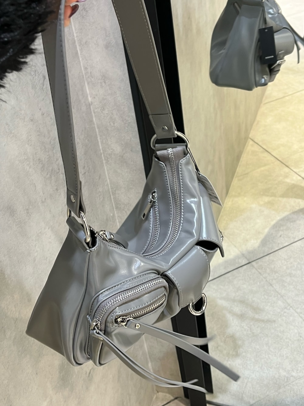 ブラック系のブーツ、グレー系のハンドバッグ、ブラック系のスカートを着用したレディースの秋コーディネートの10枚目の写真