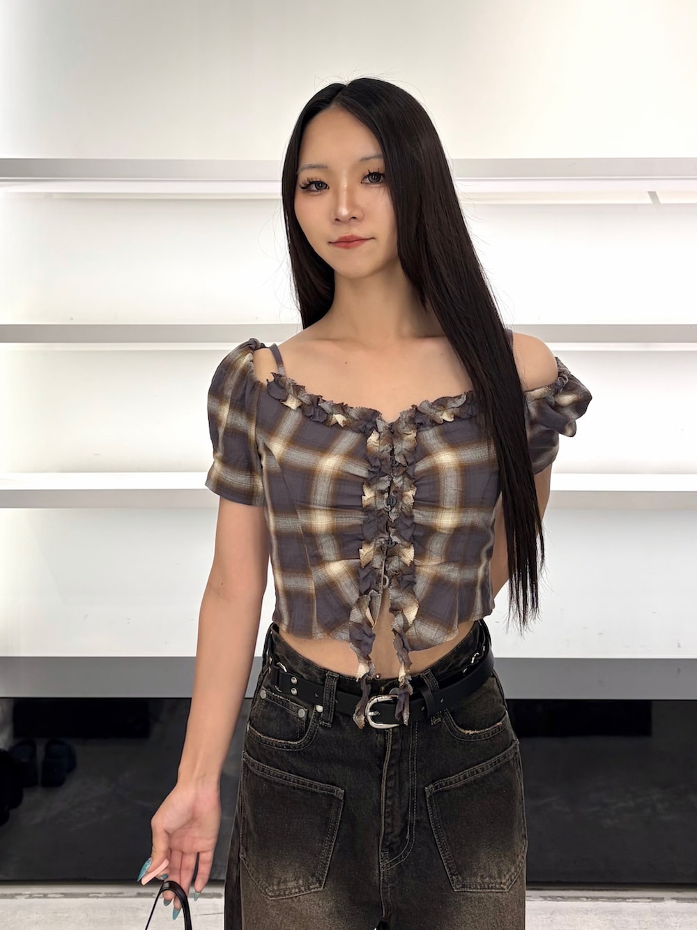 ブラウン系のTシャツ/カットソー、ブラック系のハンドバッグ、ブラック系のデニムパンツを着用したレディースの夏コーディネートの6枚目の写真