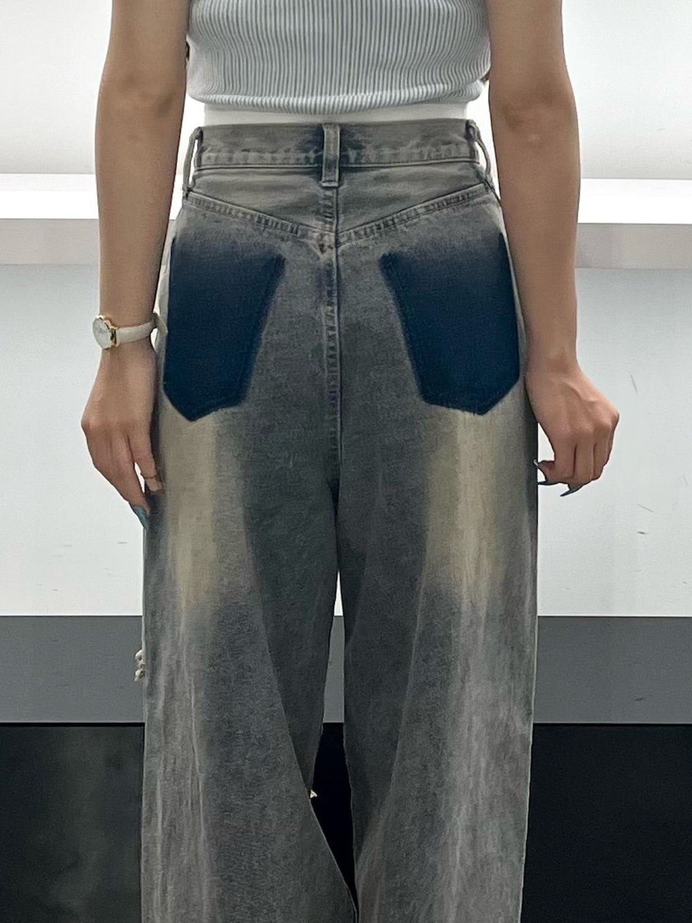 ブルー系のデニムパンツ、ブラック系のサンダル、ブラウン系のハンチング/ベレー帽を着用したレディースの夏コーディネートの8枚目の写真