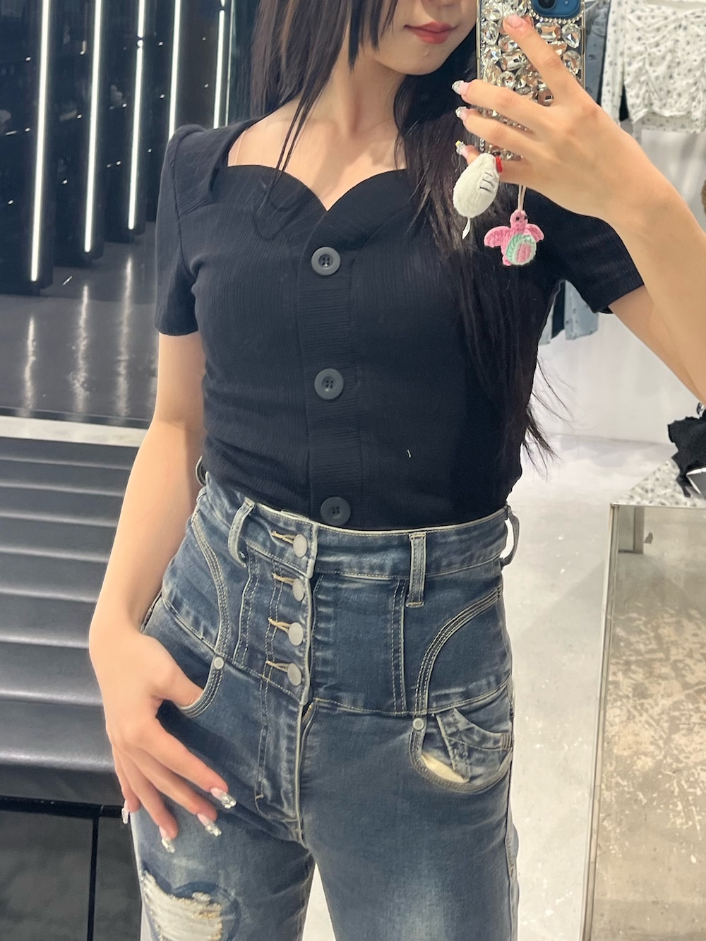 ブラック系のTシャツ/カットソー、ブルー系のデニムパンツ、ブラック系のサンダルを着用したレディースの春コーディネートの4枚目の写真