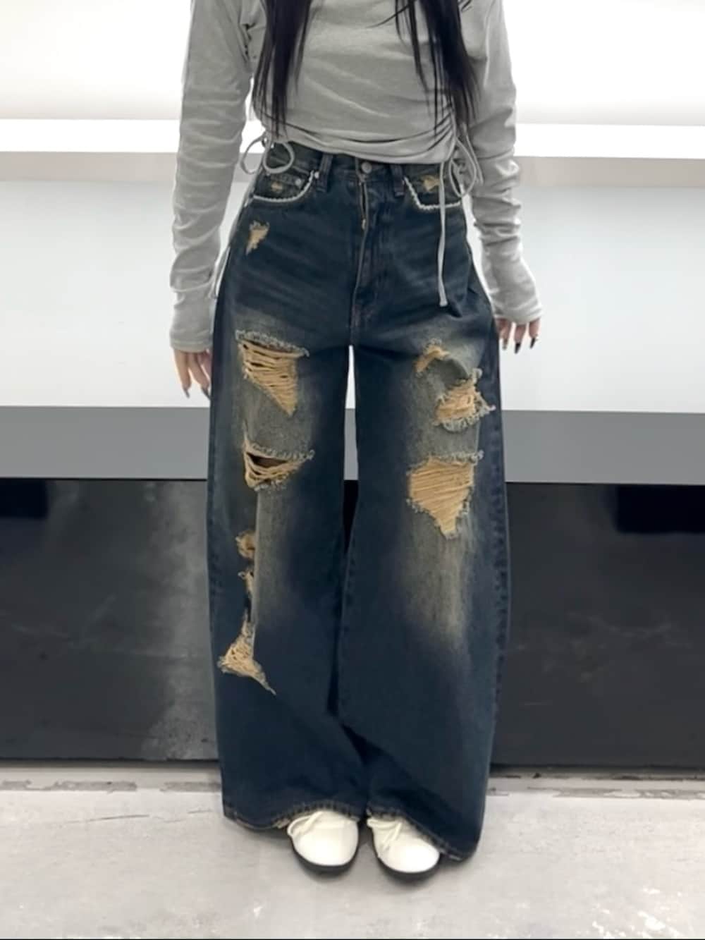 グレー系のTシャツ/カットソー、ブルー系のデニムパンツ、ホワイト系のスニーカーを着用したレディースの春コーディネートの9枚目の写真