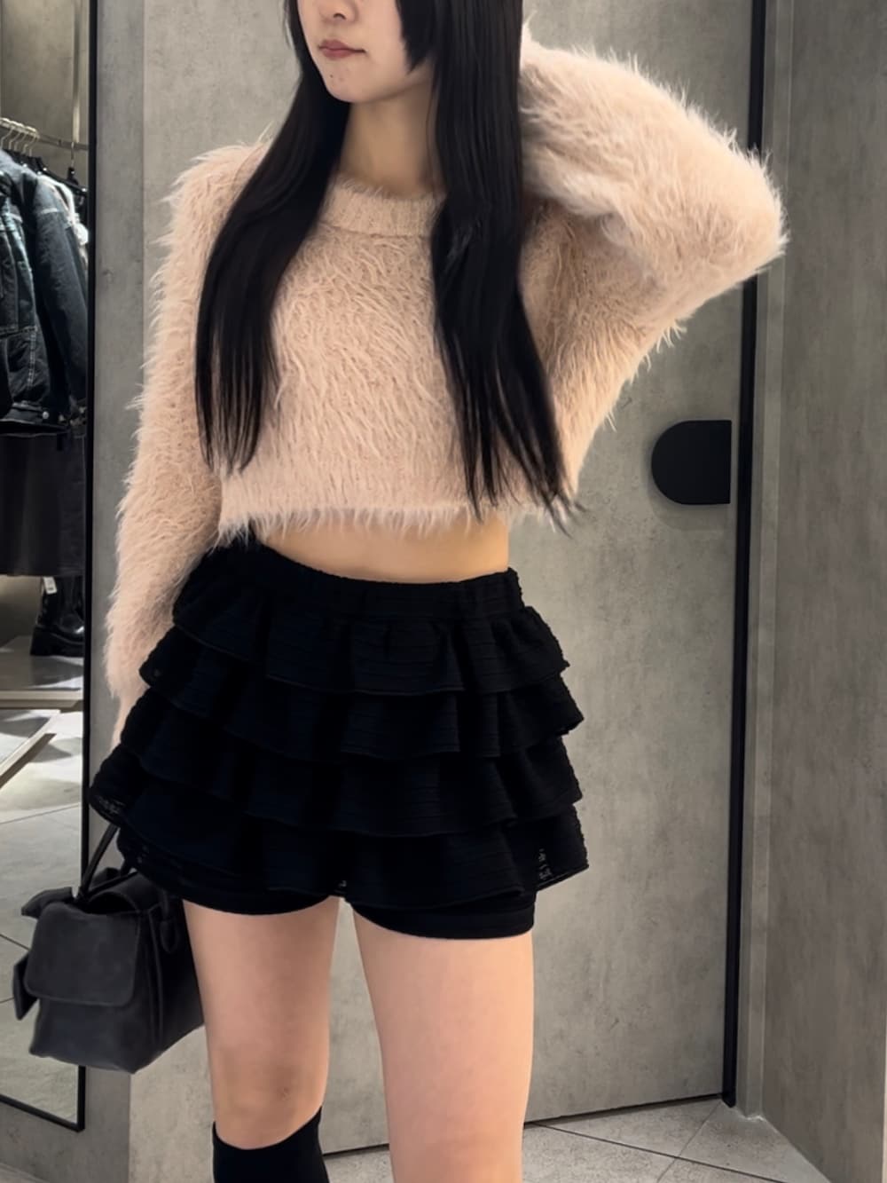 ピンク系のニット/セーター、ブラック系のハンドバッグ、ブラック系のその他パンツを着用したレディースの冬コーディネートの6枚目の写真