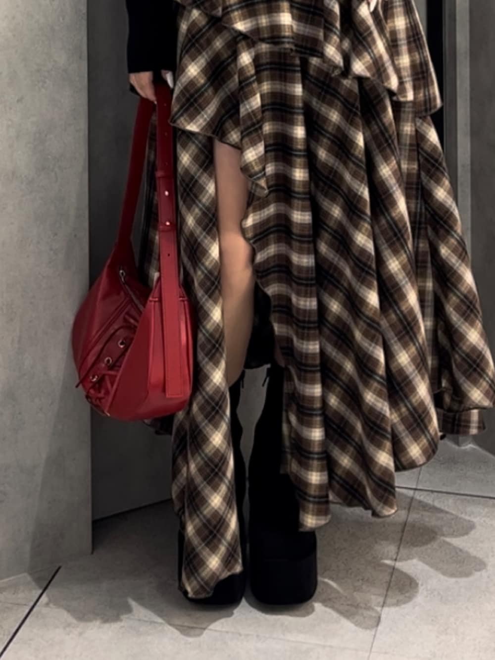 ブラック系のニット/セーター、ベージュ系のワンピース、レッド系のショルダーバッグを着用したレディースの冬コーディネートの10枚目の写真