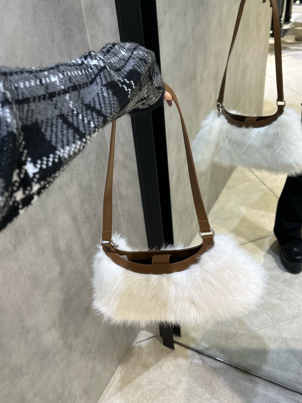 ブラック系のニット/セーター、ブラック系のデニムパンツ、ブラック系のブーツを着用したレディースの冬コーディネートの9枚目の写真