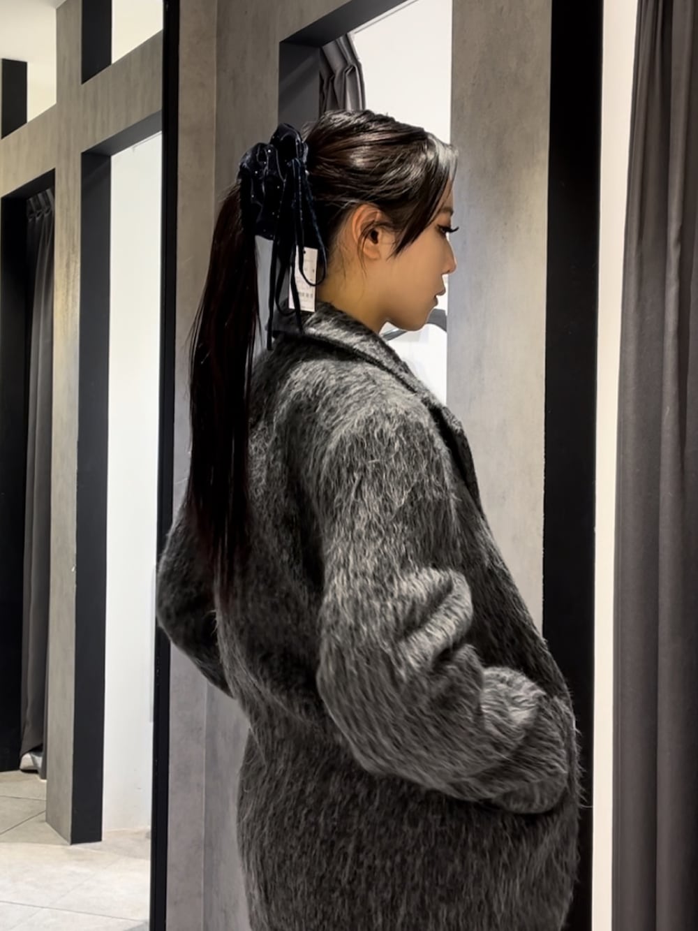 グレー系のその他アウター、ブラック系のニット/セーター、グレー系のその他パンツを着用したレディースの冬コーディネートの6枚目の写真