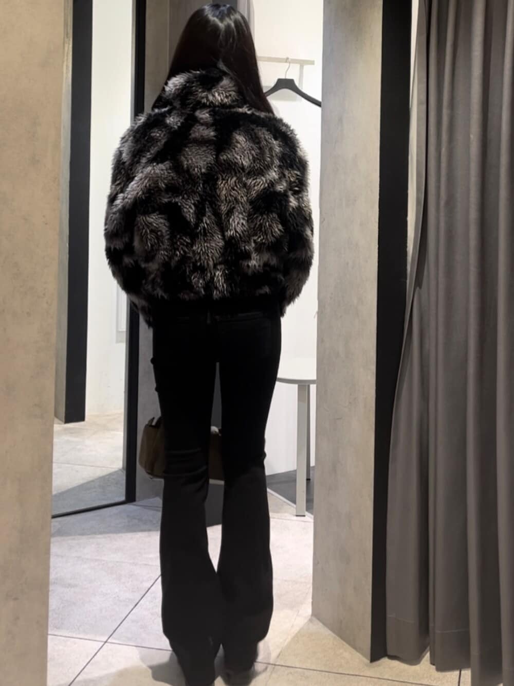 ブルー系のブルゾン、ブラック系のデニムパンツ、ブラック系のブーツを着用したレディースの冬コーディネートの4枚目の写真