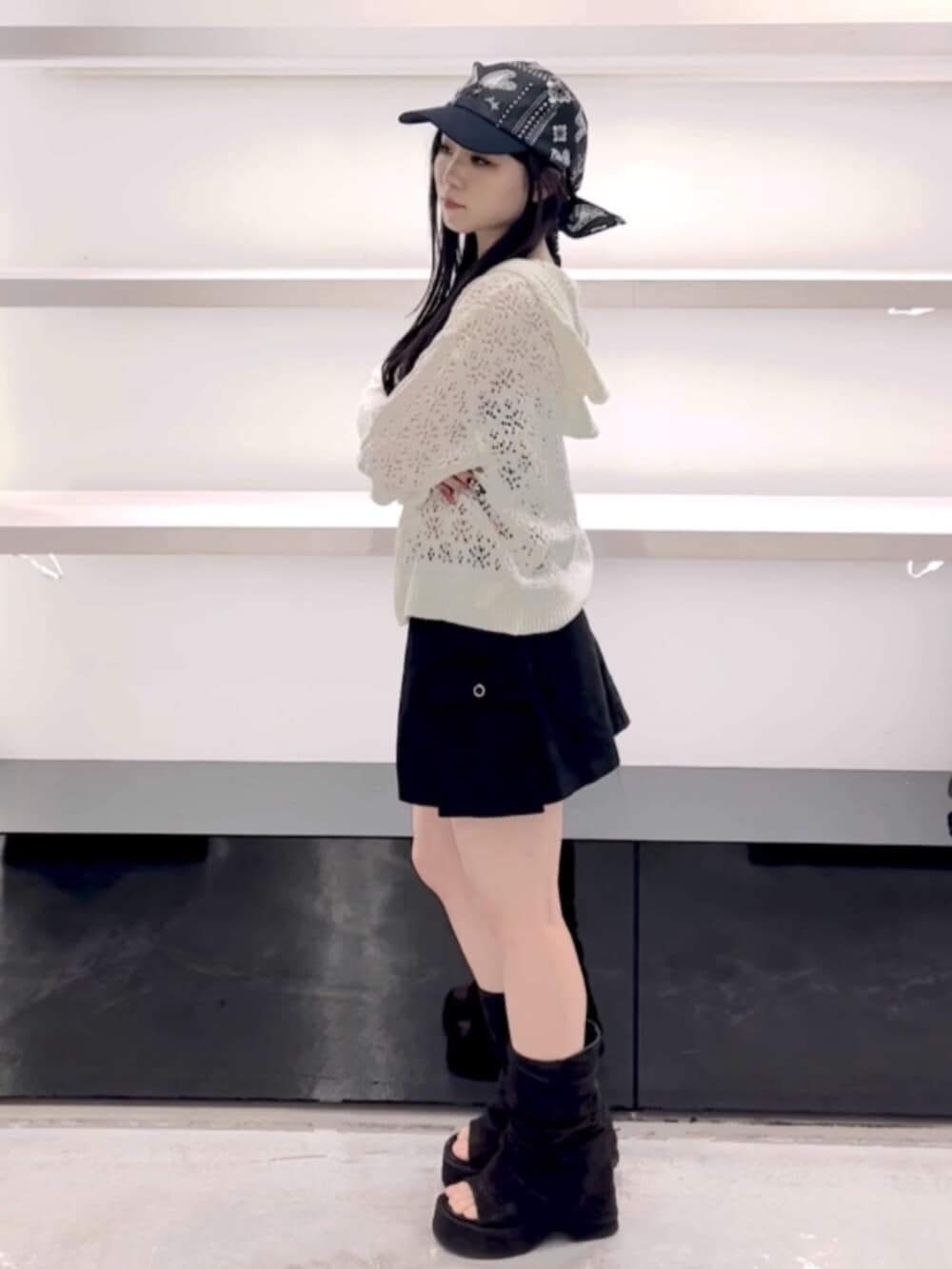 ブラック系のサンダル、ホワイト系のパーカー、ブラック系のスカートを着用したレディースの春コーディネートの10枚目の写真