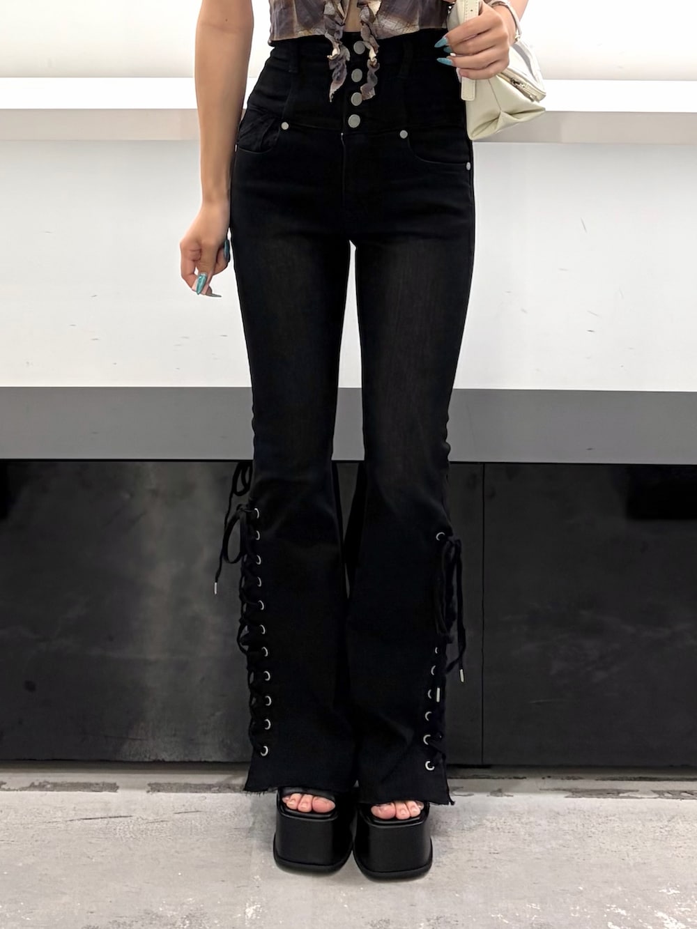 ブラウン系のTシャツ/カットソー、ホワイト系のハンドバッグ、ブラック系のデニムパンツを着用したレディースの夏コーディネートの5枚目の写真