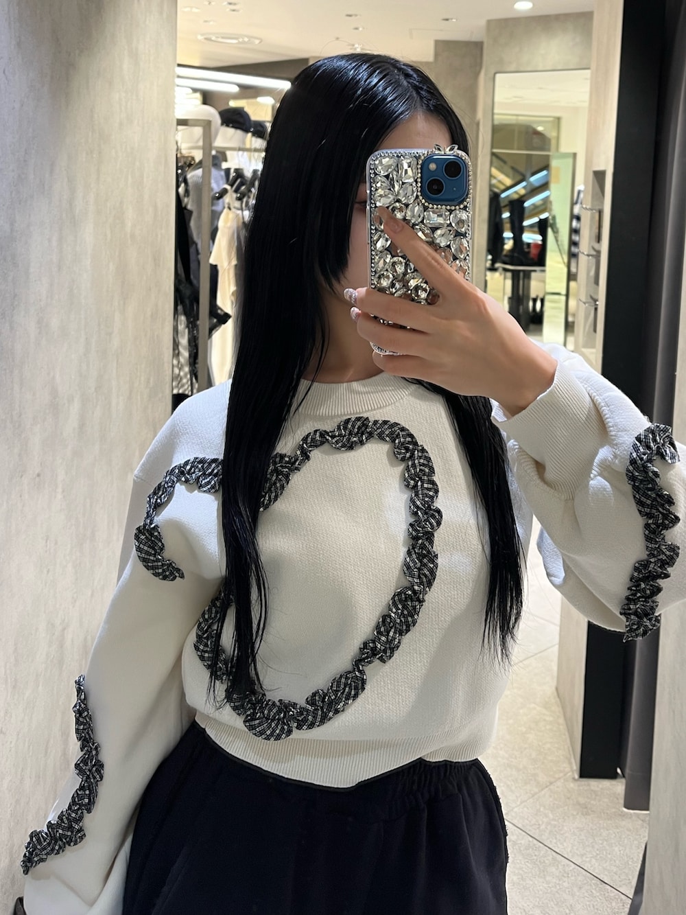 ホワイト系のニット/セーター、ブラック系のスウェットパンツ、ブラック系のハンドバッグを着用したレディースの冬コーディネートの4枚目の写真