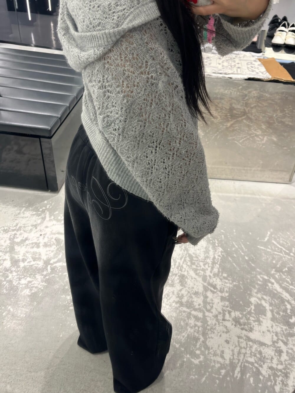グレー系のパーカー、ブラック系のスウェットパンツ、ホワイト系のニット/セーターを着用したレディースの春コーディネートの8枚目の写真