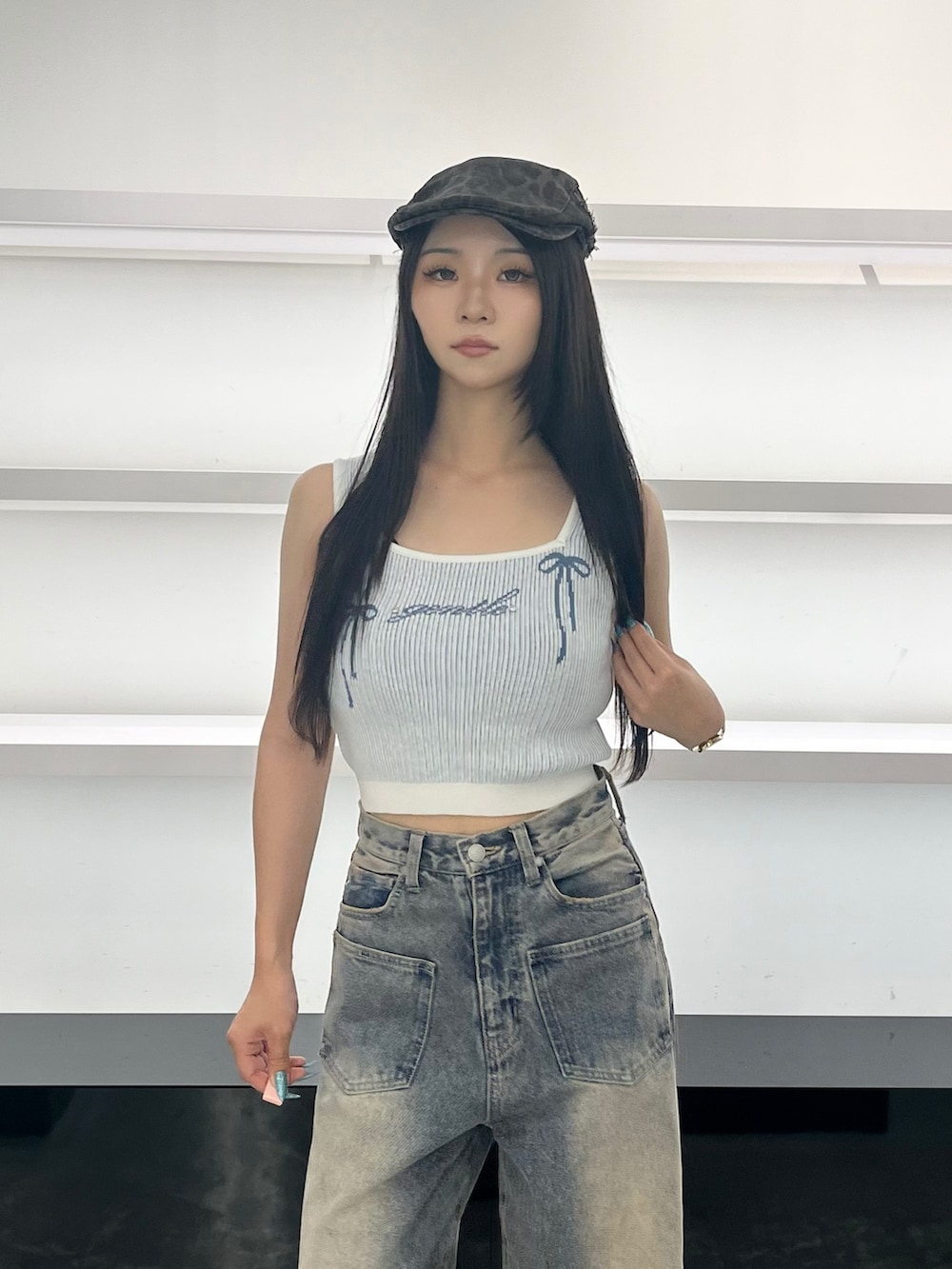 ブルー系のデニムパンツ、ブラック系のサンダル、ブラウン系のハンチング/ベレー帽を着用したレディースの夏コーディネートの7枚目の写真