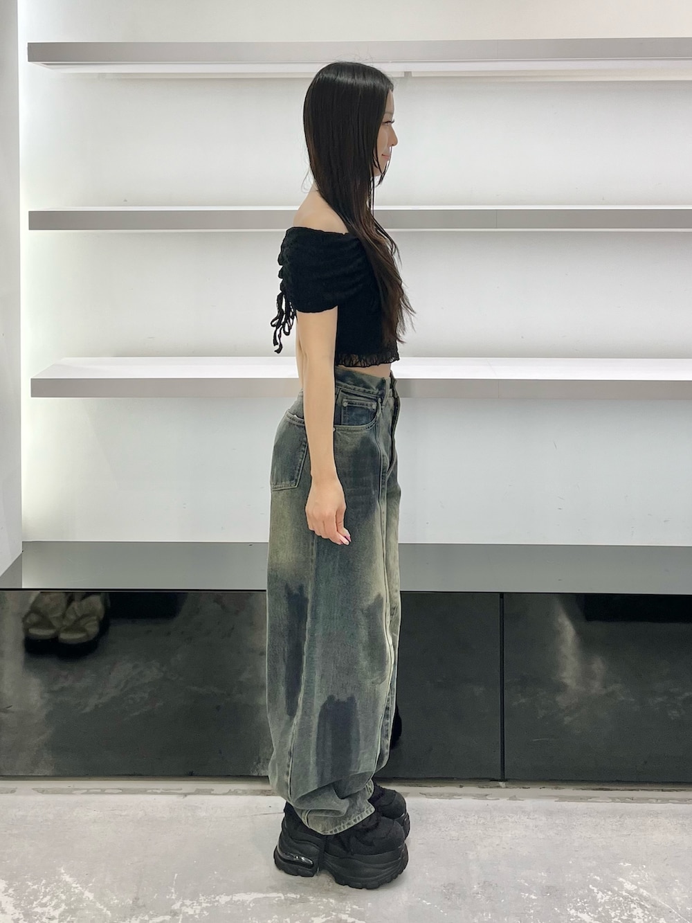 ブラック系のスニーカー、ブルー系のデニムパンツ、ブラック系のTシャツ/カットソーを着用したレディースの夏コーディネートの2枚目の写真
