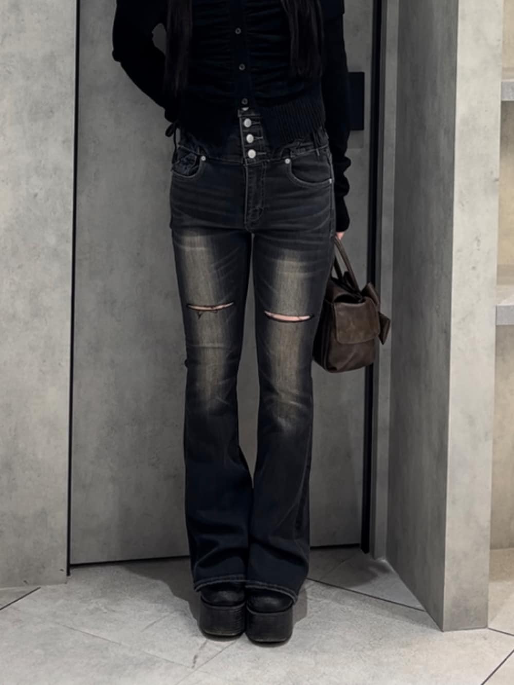 ブラック系のニット/セーター、ブラック系のデニムパンツ、ブラウン系のハンドバッグを着用したレディースの冬コーディネートの9枚目の写真