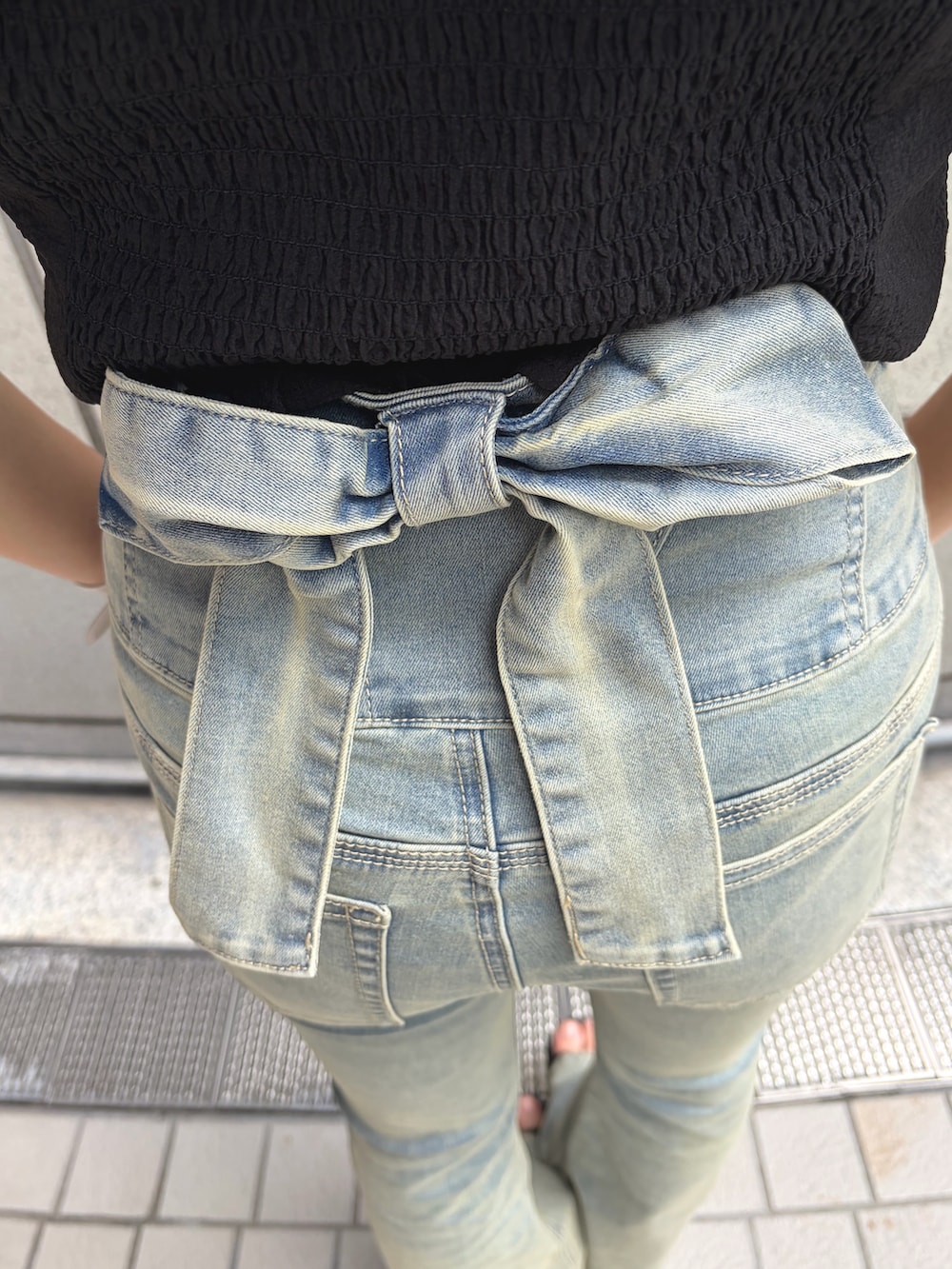 ブラック系のTシャツ/カットソー、ブルー系のデニムパンツ、ブラック系のサンダルを着用したレディースの夏コーディネートの9枚目の写真