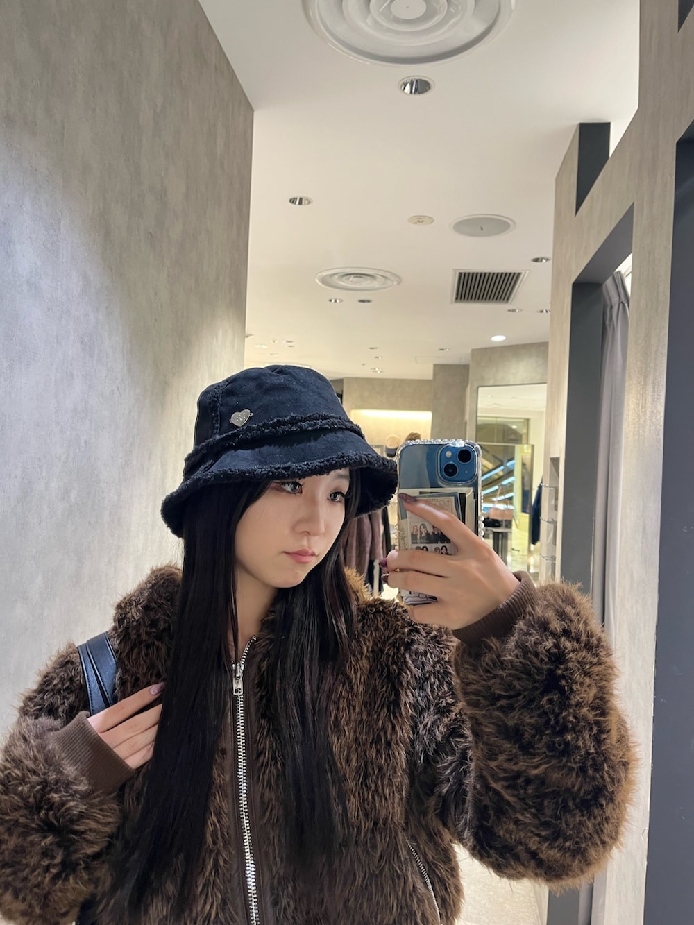 ブラック系のブーツ、ブラック系のハンドバッグ、ブルー系のスカートを着用したレディースの秋コーディネートの8枚目の写真