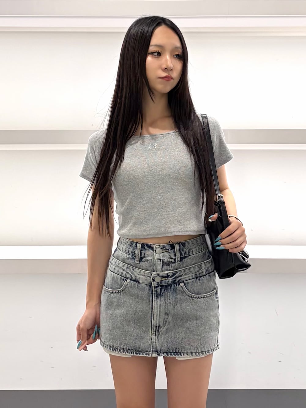 ブルー系のスカート、ブラック系のハンドバッグ、ブルー系のサンダルを着用したレディースの夏コーディネートの9枚目の写真