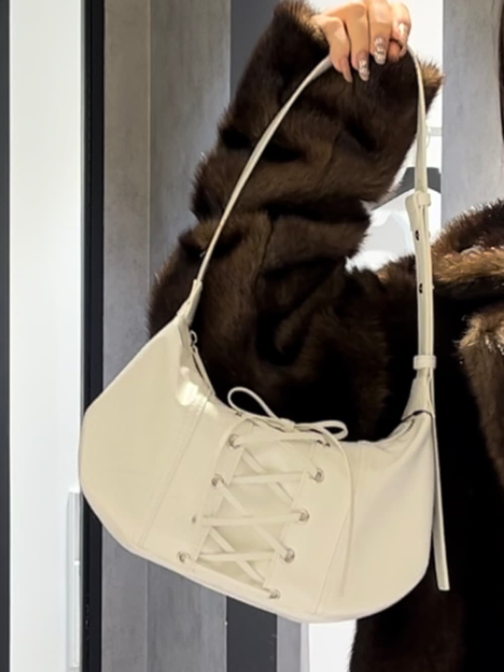 ブラウン系のその他アウター、ホワイト系のショルダーバッグ、ブラック系のブーツを着用したレディースの冬コーディネートの9枚目の写真