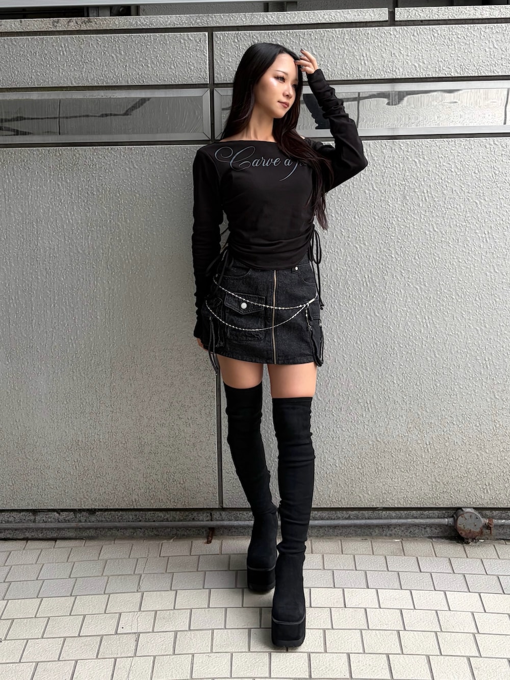 ブラック系のTシャツ/カットソー、ブラック系のスカート、ブラック系のブーツを着用したレディースの秋コーディネートの8枚目の写真