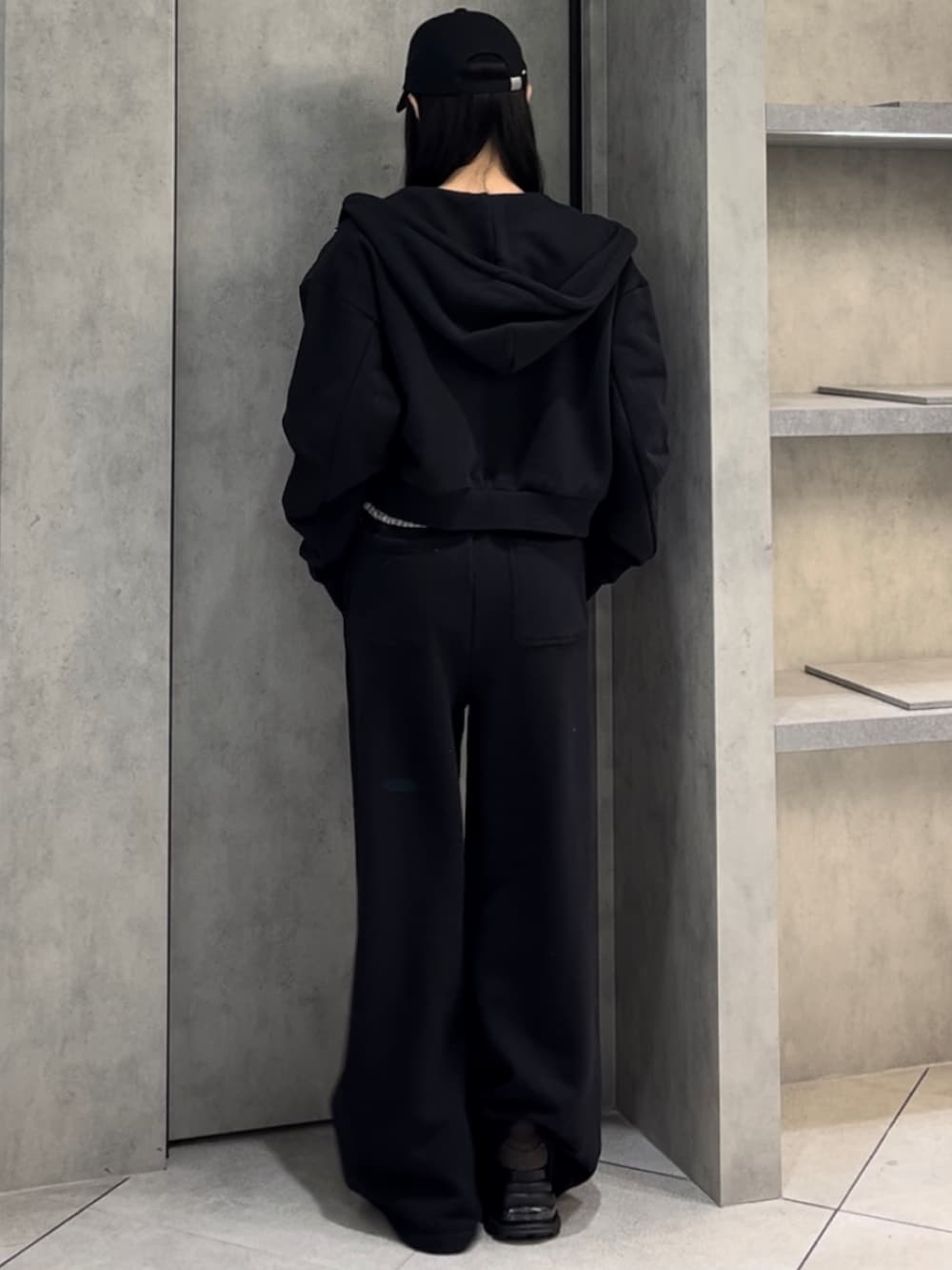 ホワイト系のニット/セーター、ブラック系のパーカー、ブラック系のスウェットパンツを着用したレディースの冬コーディネートの4枚目の写真