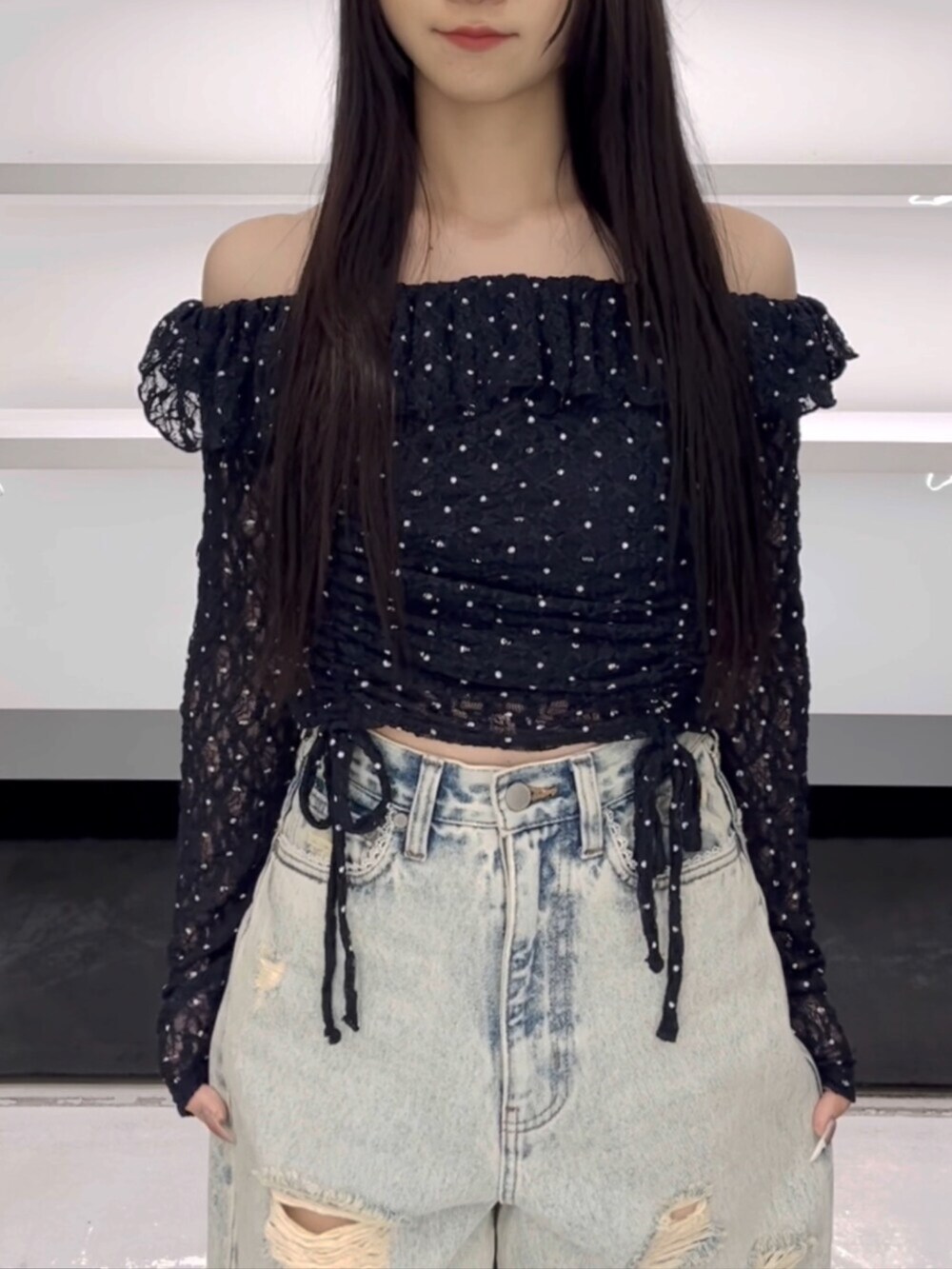 ブラック系のスニーカー、ブルー系のTシャツ/カットソー、ブルー系のデニムパンツを着用したレディースの春コーディネートの6枚目の写真