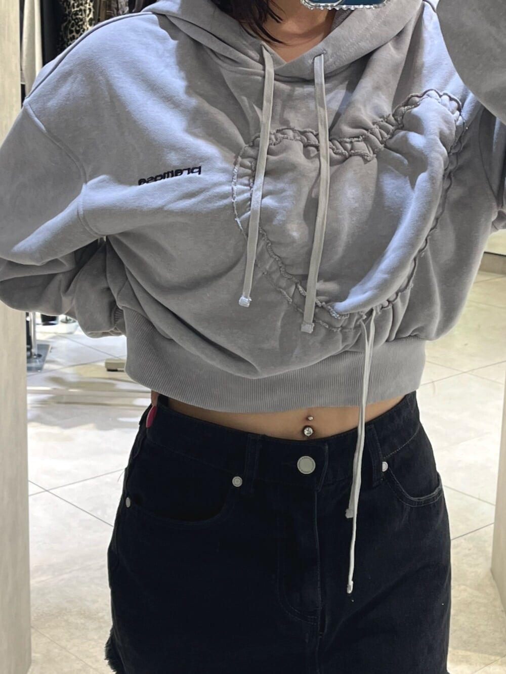 ブラック系のブーツ、グレー系のパーカー、ブラック系のスカートを着用したレディースの秋コーディネートの7枚目の写真