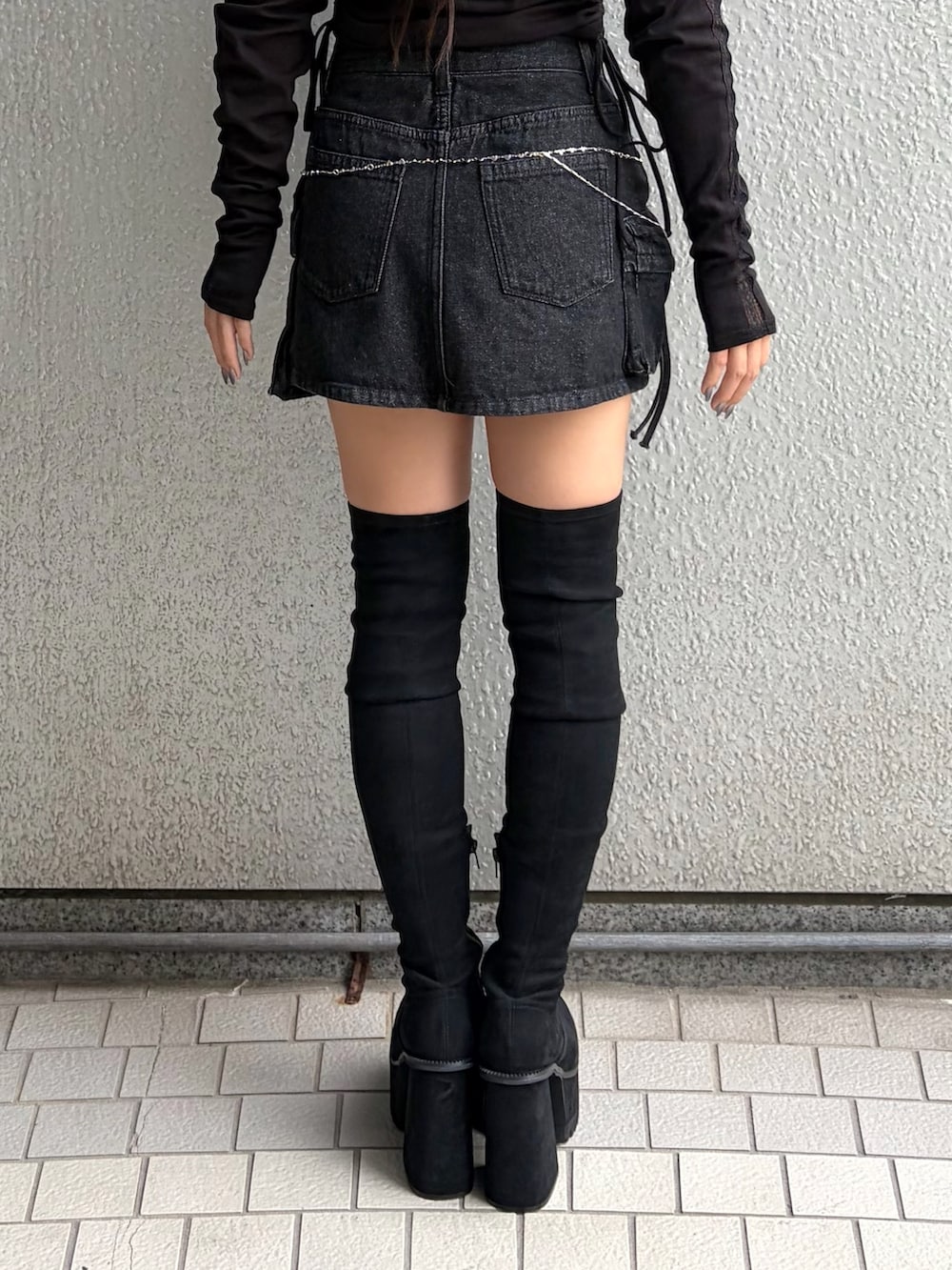 ブラック系のTシャツ/カットソー、ブラック系のスカート、ブラック系のブーツを着用したレディースの秋コーディネートの10枚目の写真