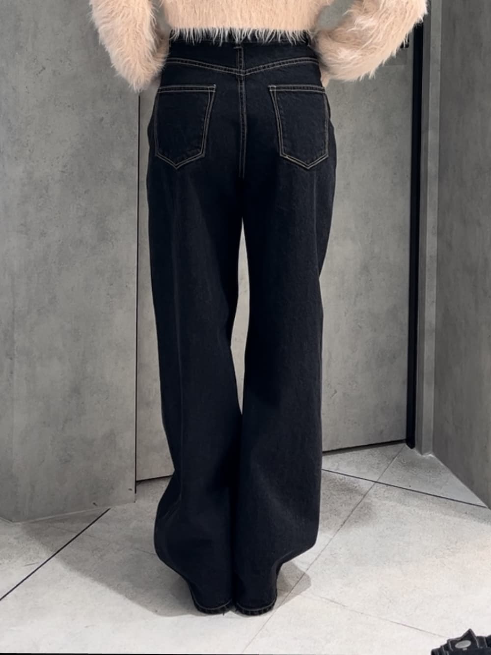 ブルー系のブルゾン、ブルー系のデニムパンツ、ブラック系のハンドバッグを着用したレディースの冬コーディネートの7枚目の写真