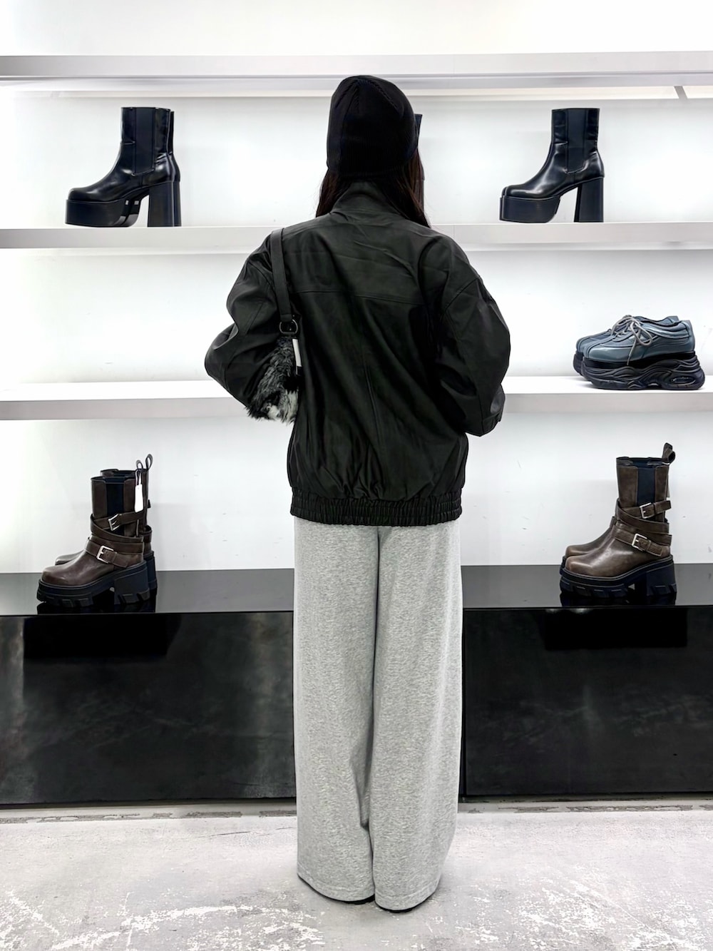 ブラック系のブルゾン、ブラック系のショルダーバッグ、グレー系のその他パンツを着用したレディースの秋コーディネートの5枚目の写真