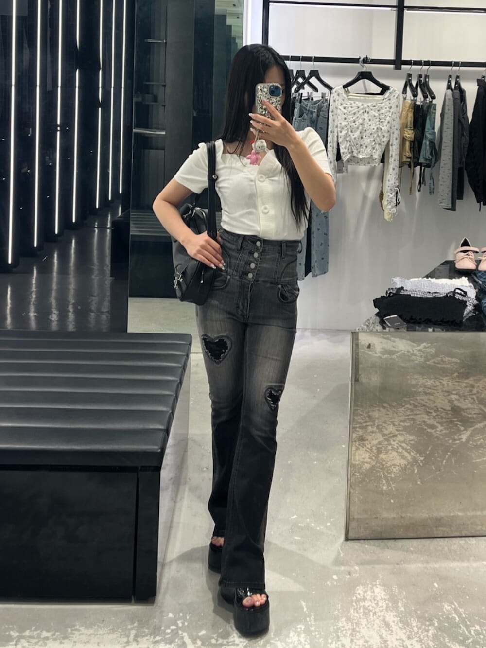 ブラック系のデニムパンツ、ブラック系のサンダル、ホワイト系のTシャツ/カットソーを着用したレディースの春コーディネートの7枚目の写真