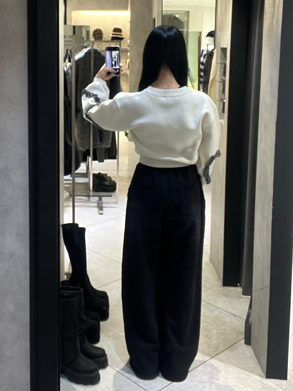 ホワイト系のニット/セーター、ブラック系のスウェットパンツ、ブラック系のハンドバッグを着用したレディースの冬コーディネートの3枚目の写真