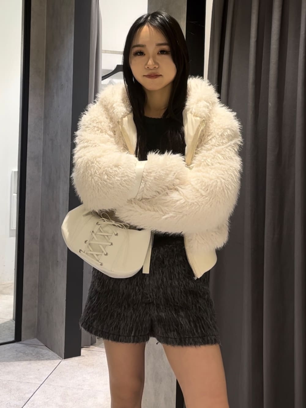 ホワイト系のブルゾン、ブラック系のニット/セーター、グレー系のその他パンツを着用したレディースの冬コーディネートの8枚目の写真