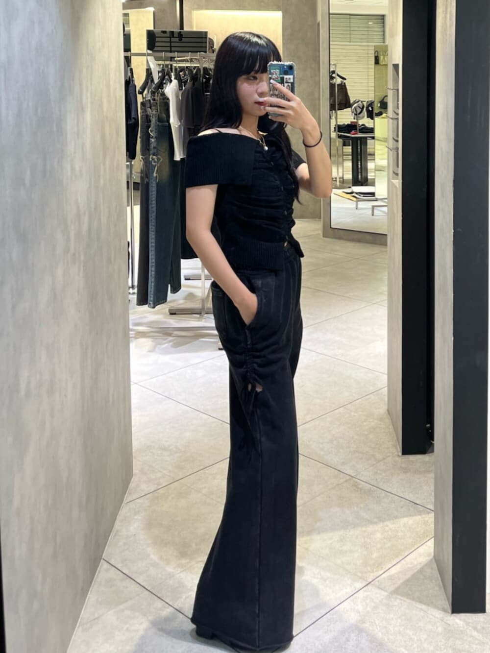 ブラウン系のニット/セーター、ブラック系のスウェットパンツを着用したレディースの秋コーディネートの2枚目の写真