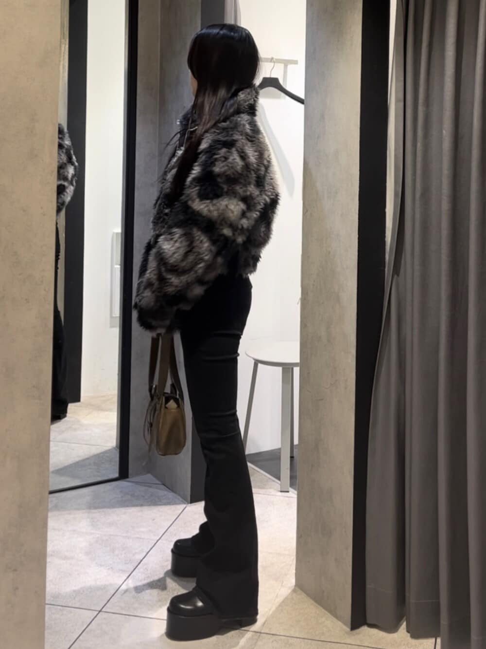 ブルー系のブルゾン、ブラック系のデニムパンツ、ブラック系のブーツを着用したレディースの冬コーディネートの2枚目の写真