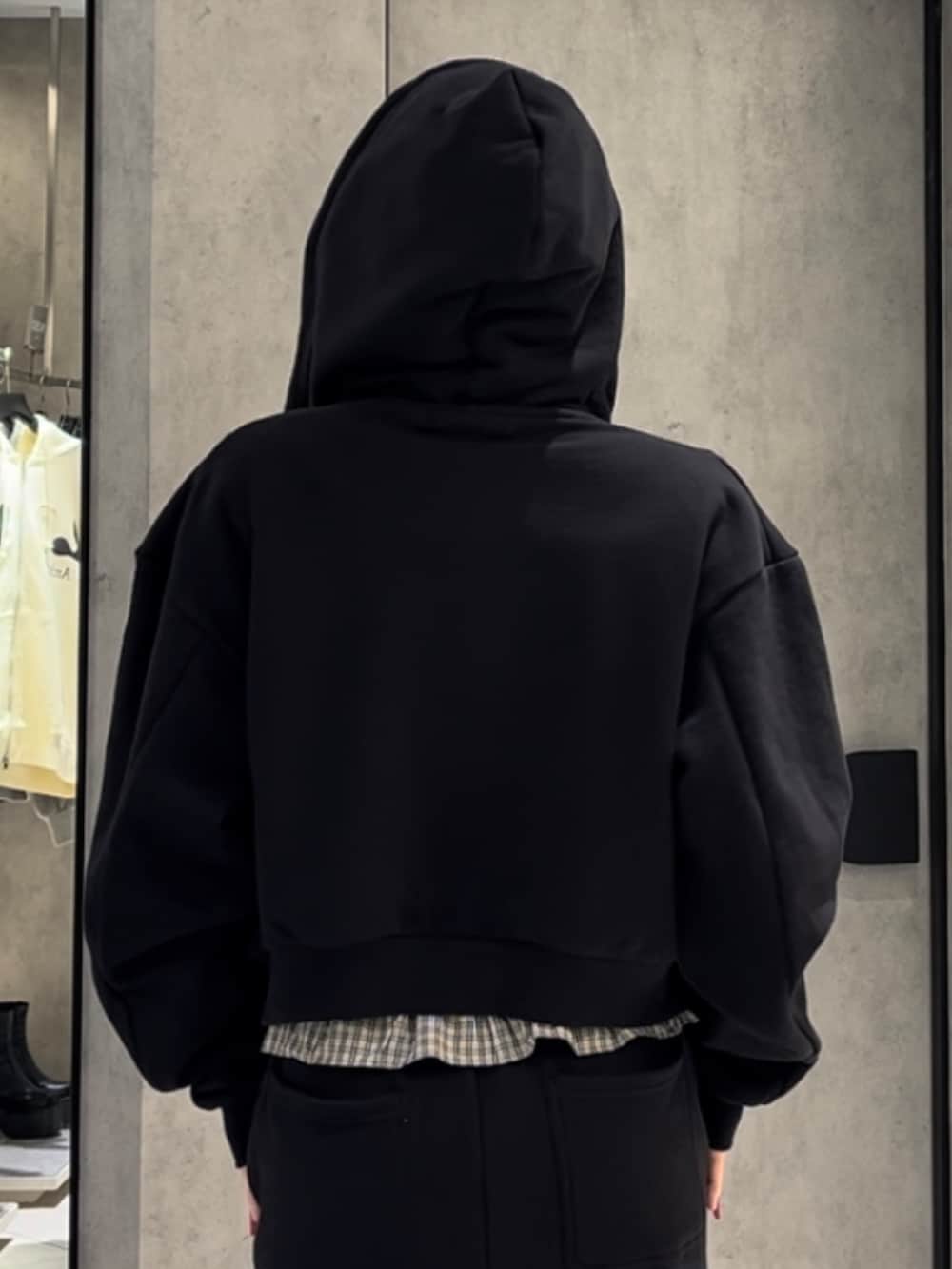 ホワイト系のニット/セーター、ブラック系のパーカー、ブラック系のスウェットパンツを着用したレディースの冬コーディネートの7枚目の写真