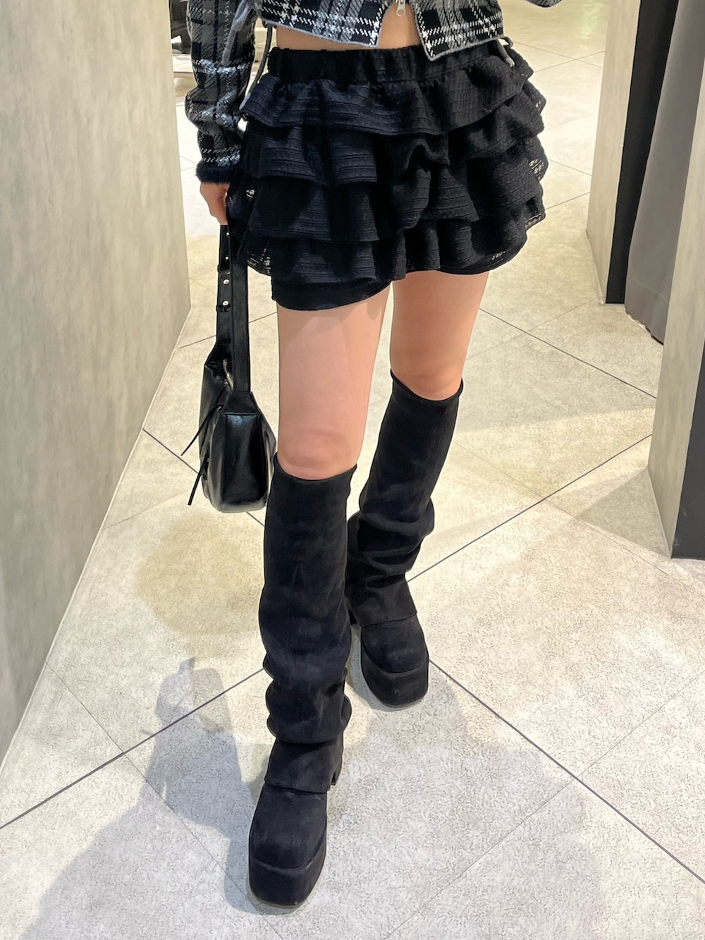 ブラック系のブーツ、ブラック系のニット/セーター、ブラック系のその他パンツを着用したレディースの冬コーディネートの7枚目の写真