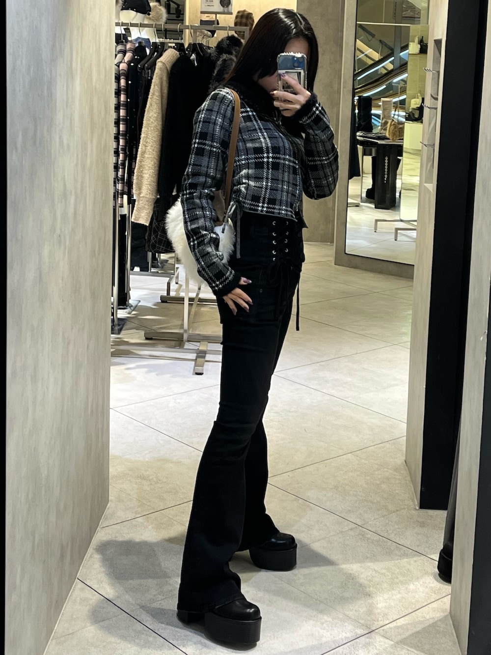 ブラック系のニット/セーター、ブラック系のデニムパンツ、ブラック系のブーツを着用したレディースの冬コーディネートの2枚目の写真