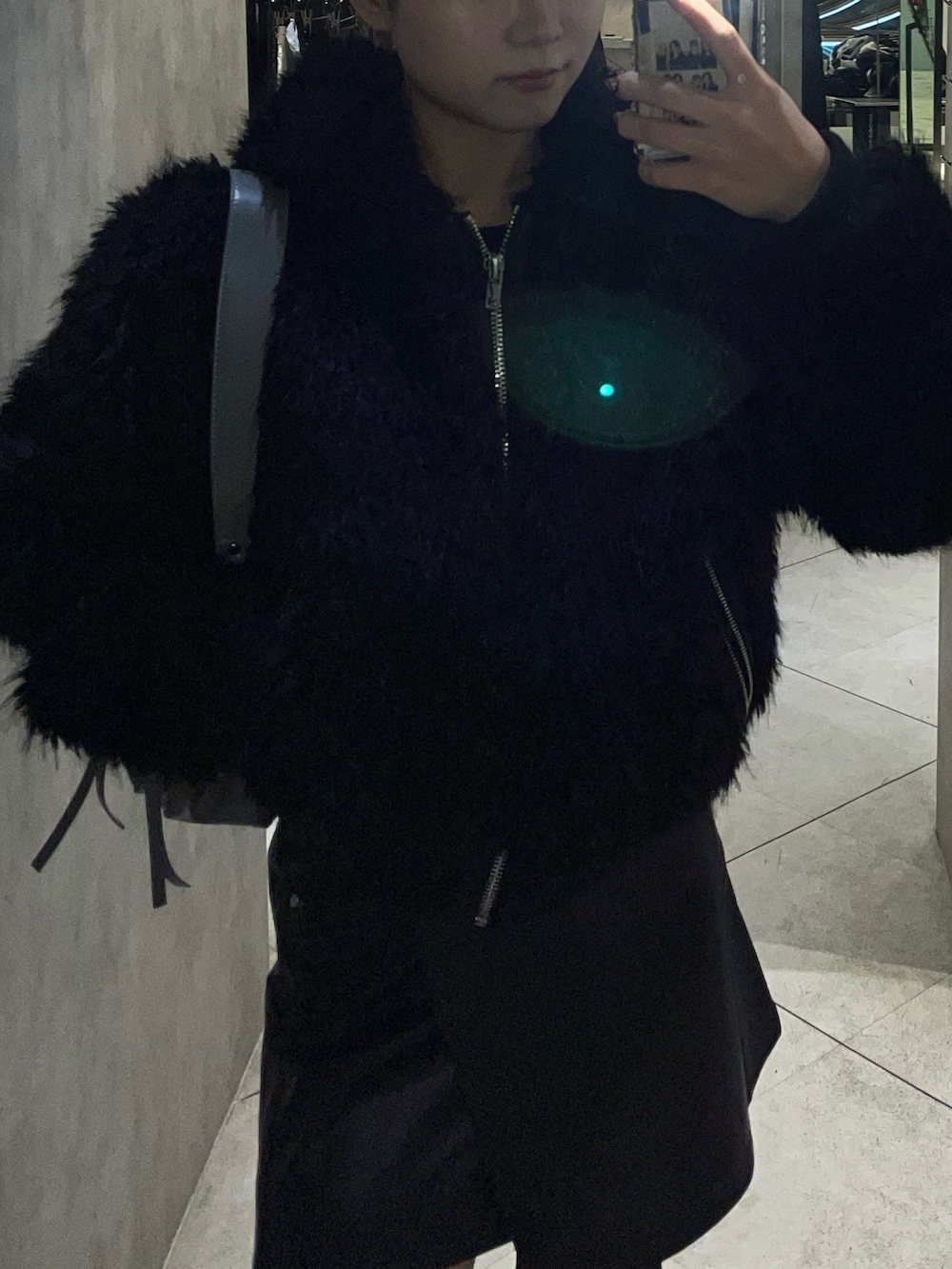 ブラック系のブーツ、グレー系のハンドバッグ、ブラック系のスカートを着用したレディースの秋コーディネートの8枚目の写真