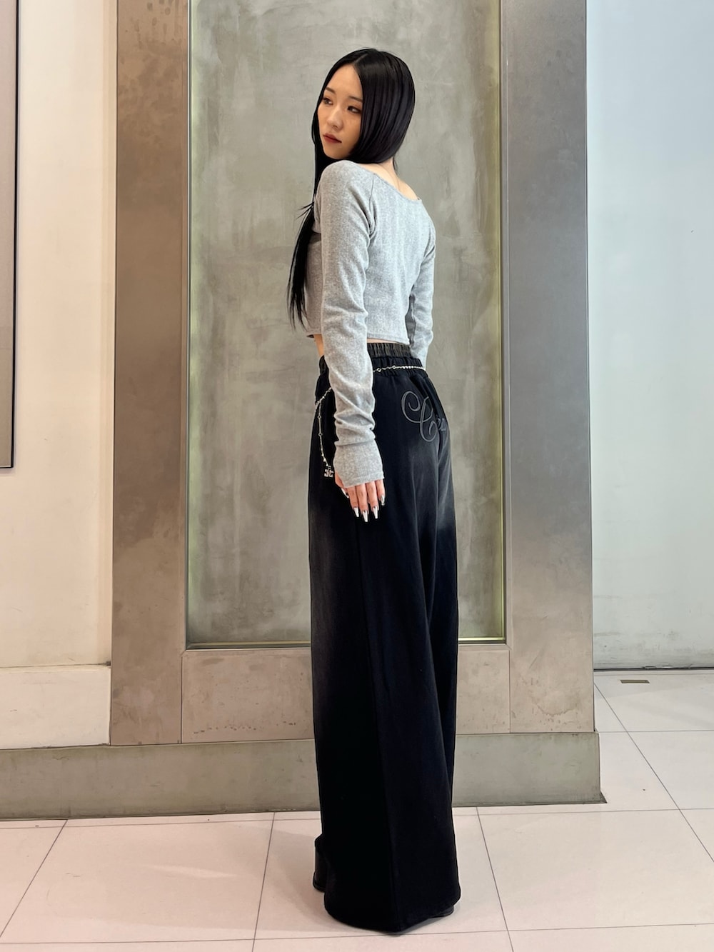 グレー系のTシャツ/カットソー、ブラック系のスウェットパンツ、ブラック系のサンダルを着用したレディースの春コーディネートの3枚目の写真