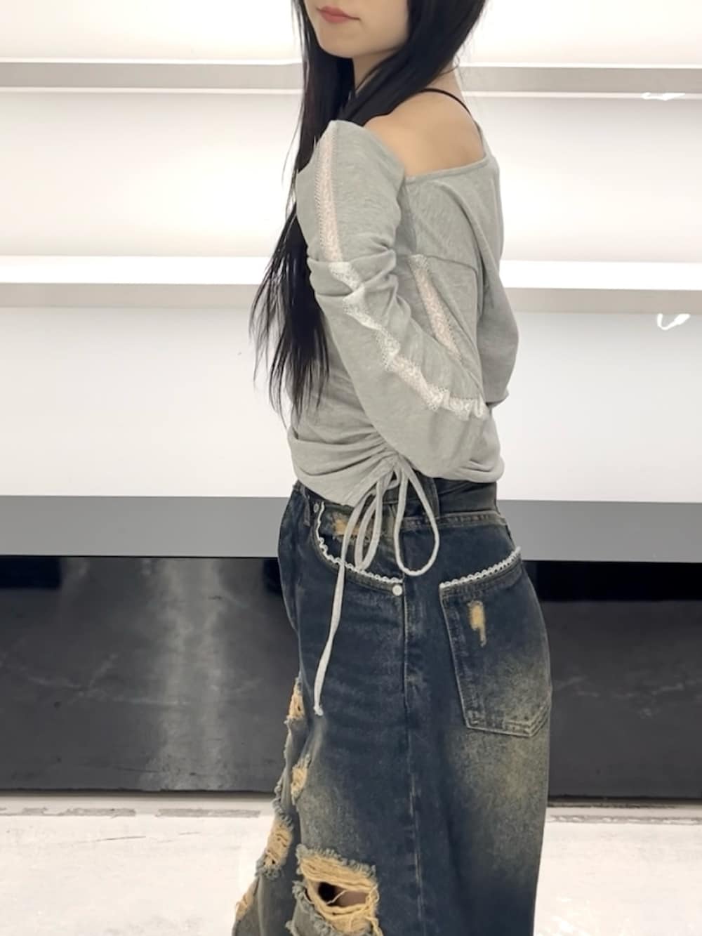 グレー系のTシャツ/カットソー、ブルー系のデニムパンツ、ホワイト系のスニーカーを着用したレディースの春コーディネートの6枚目の写真