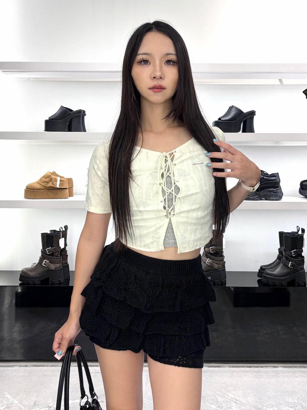 ホワイト系のTシャツ/カットソー、ブラック系のスカート、ブラック系のブーツを着用したレディースの夏コーディネートの5枚目の写真
