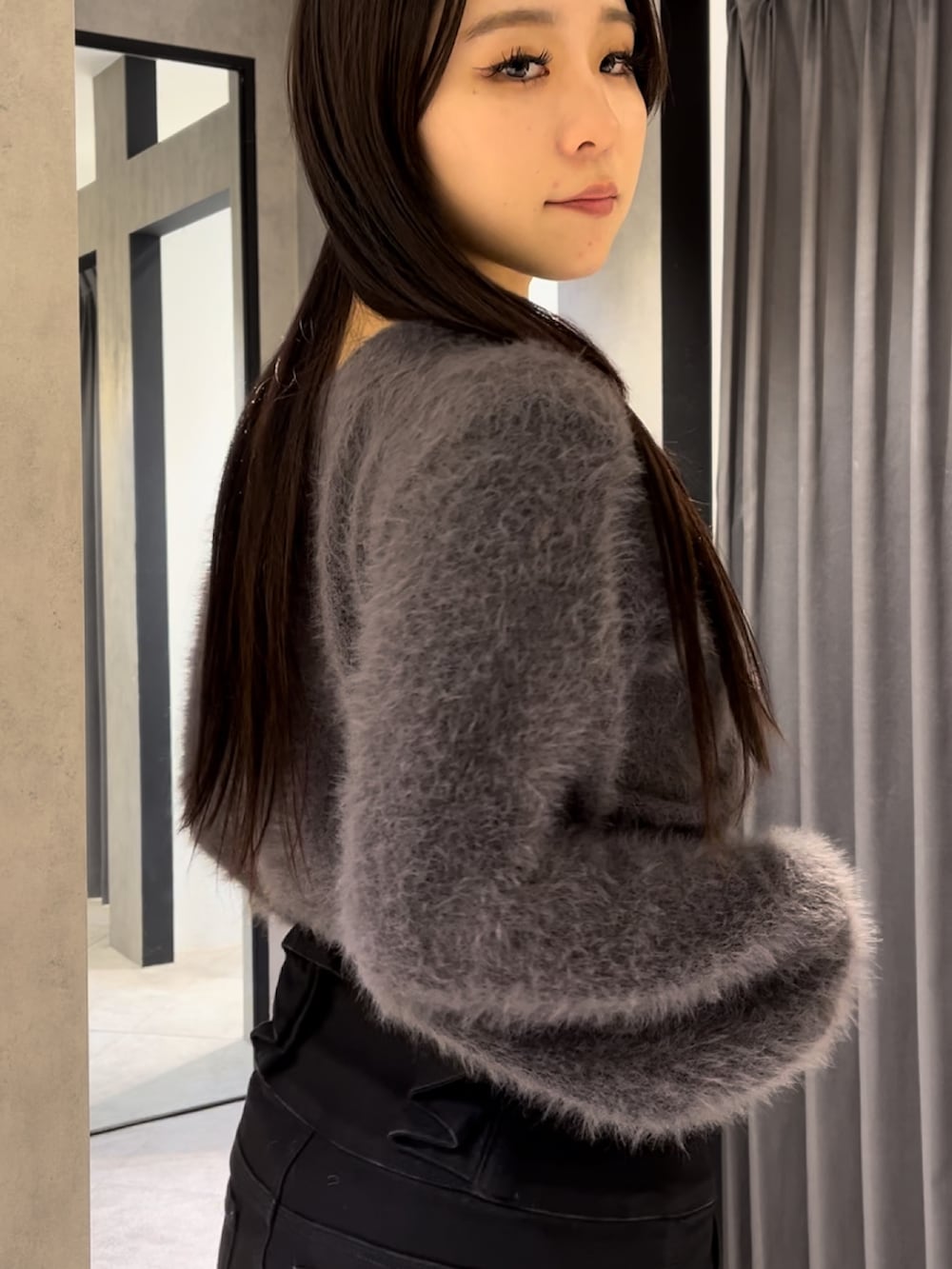 グレー系のその他アウター、グレー系のニット/セーター、ブラック系のデニムパンツを着用したレディースの冬コーディネートの8枚目の写真