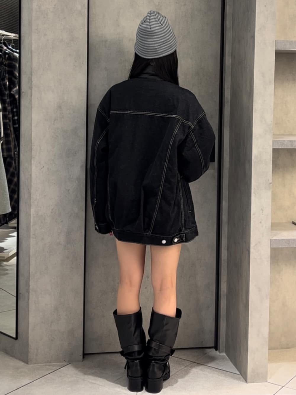 ブルー系のブルゾン、ブラック系のニット/セーター、ブルー系のスカートを着用したレディースの冬コーディネートの4枚目の写真