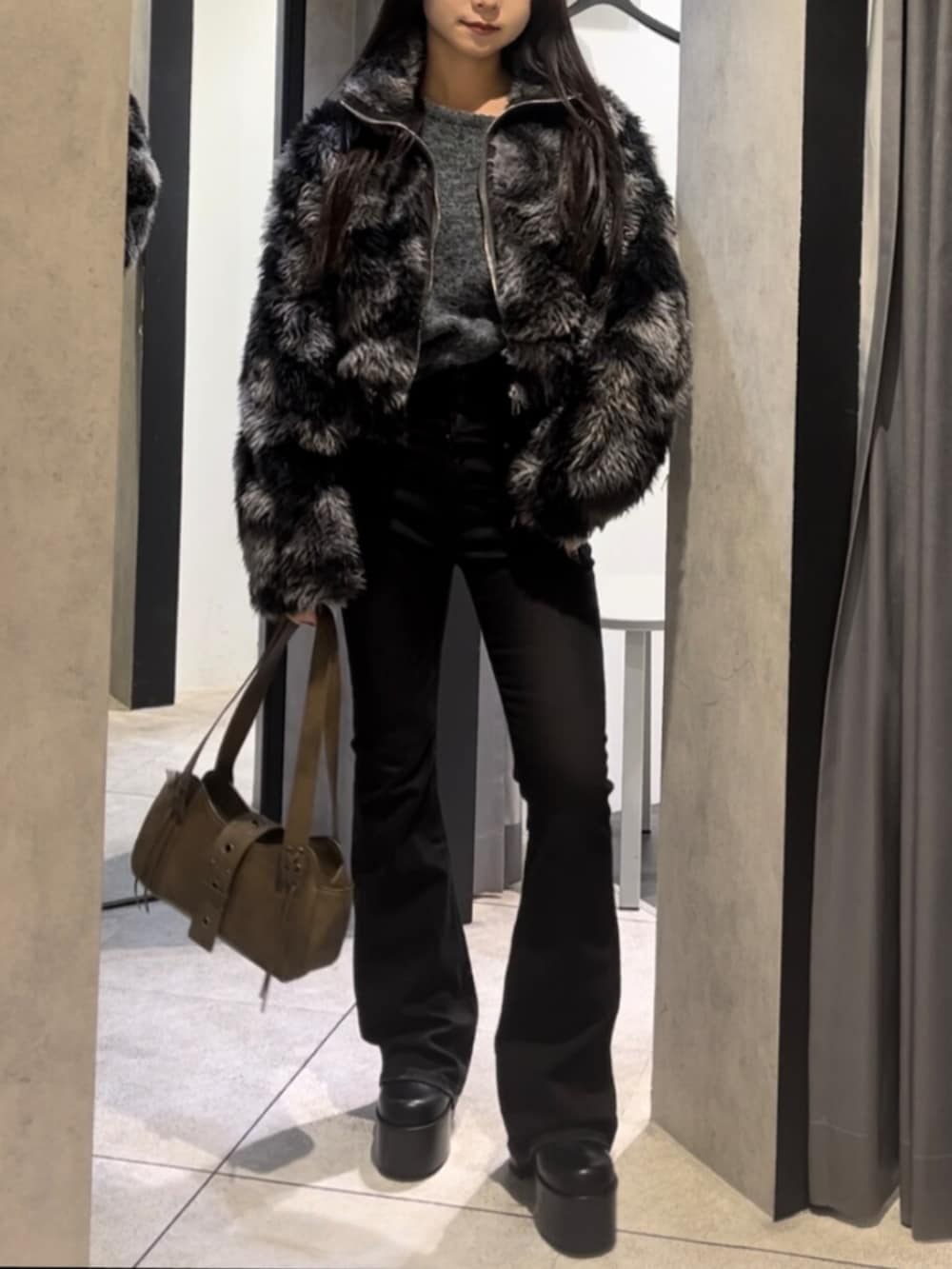 ブルー系のブルゾン、ブラック系のデニムパンツ、ブラック系のブーツを着用したレディースの冬コーディネートの3枚目の写真