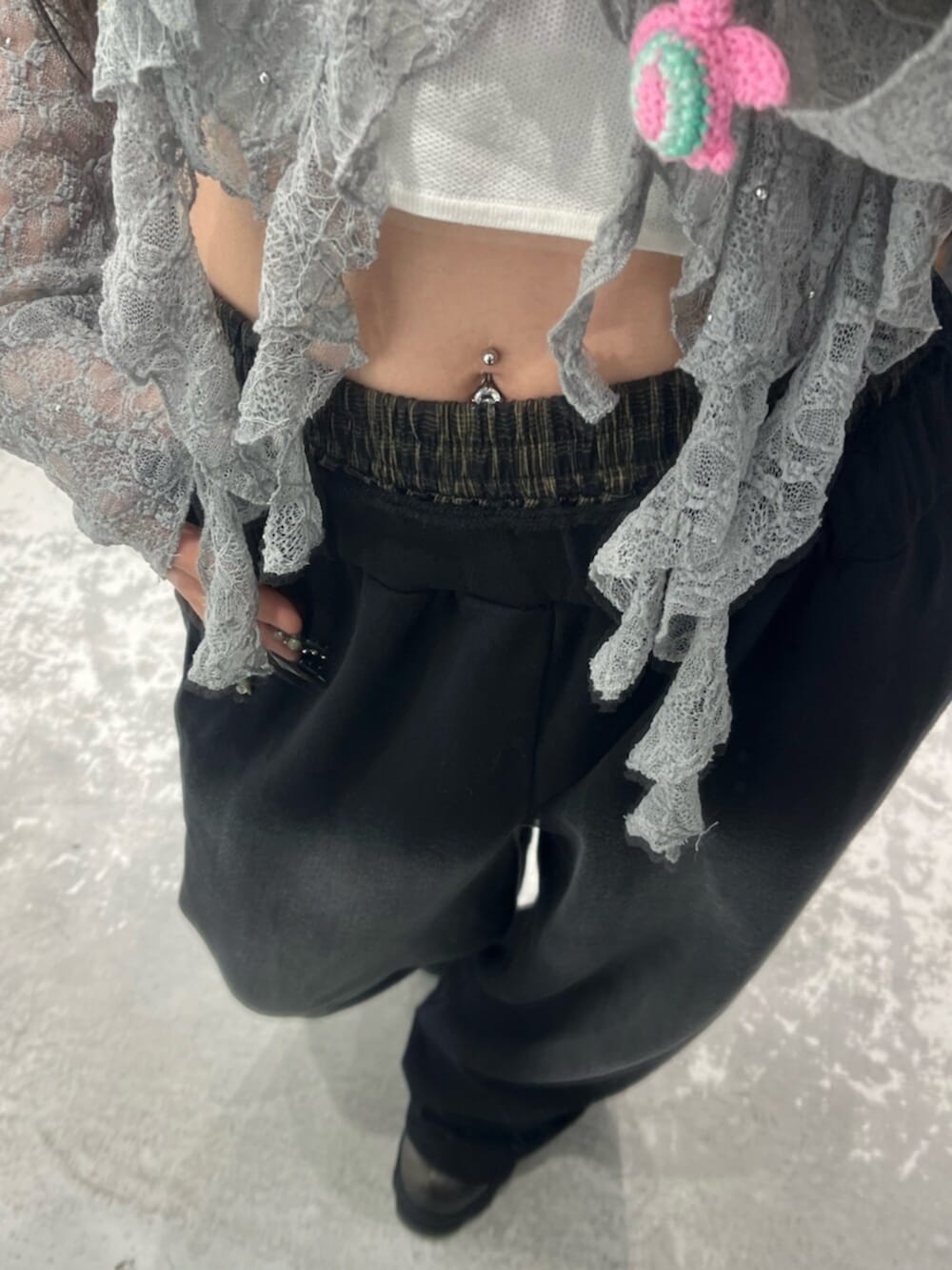 グレー系のTシャツ/カットソー、ブラック系のスウェットパンツ、ホワイト系のニット/セーターを着用したレディースの春コーディネートの7枚目の写真